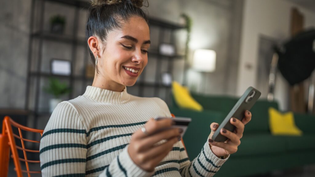 Woman holding credit card and phone