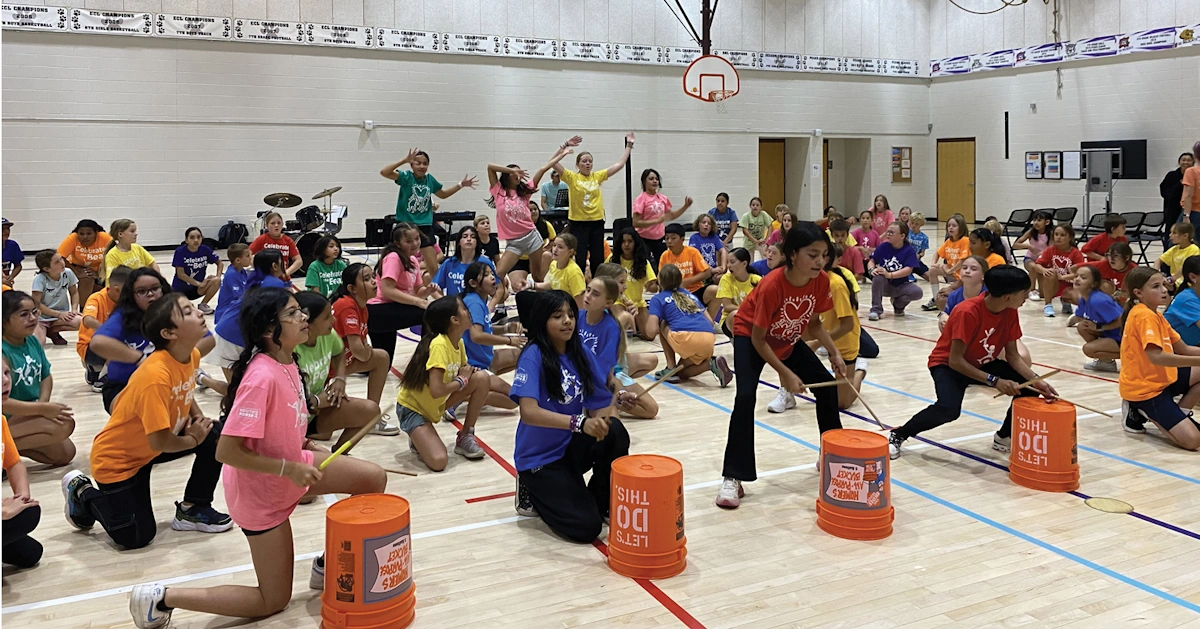 Students in gym playing drums